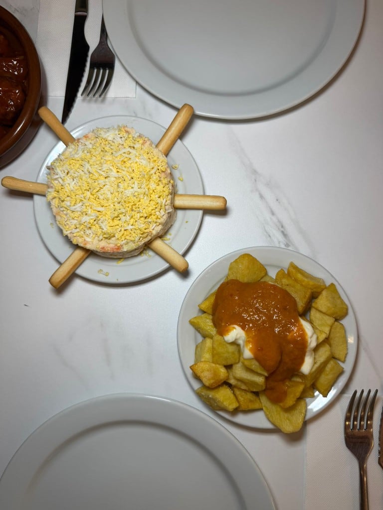 Ensaladilla rusa y patatas bravas servidas en Charlie Restaurante