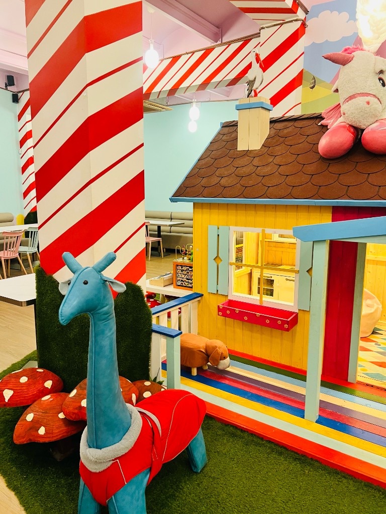 Casita de juegos de Charlie Restaurante, con columnas de caramelo y comedor al fondo