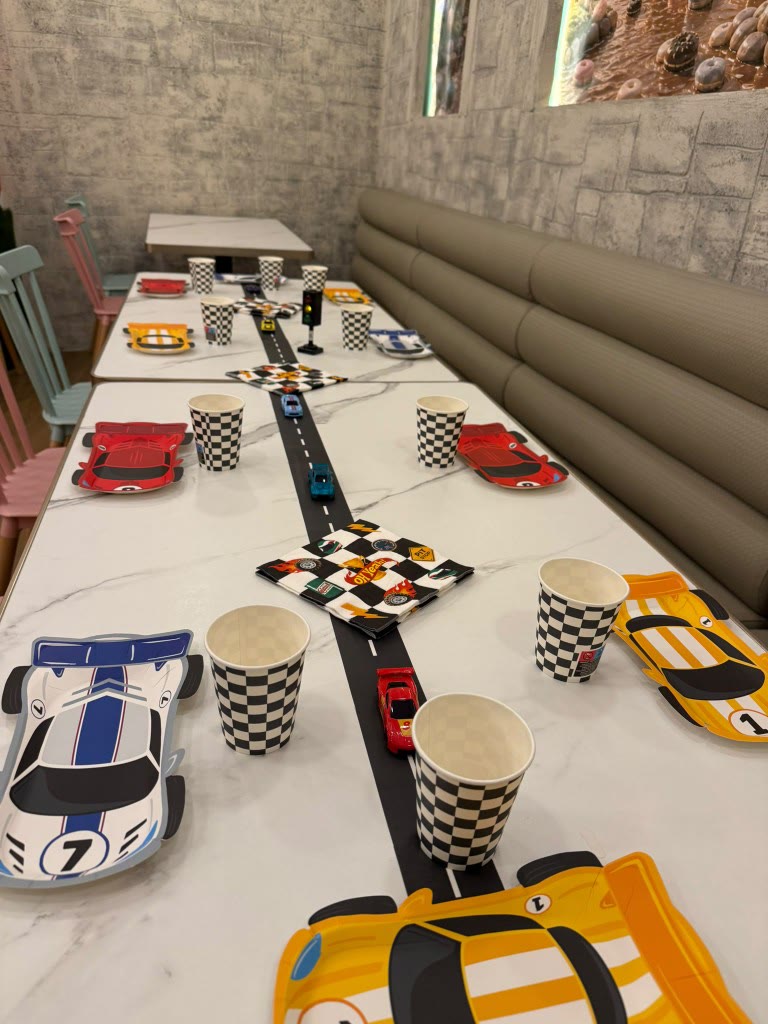 Pista de coches sobre la mesa de un cumpleaños infantil en Charlie Restaurante, Barcelona