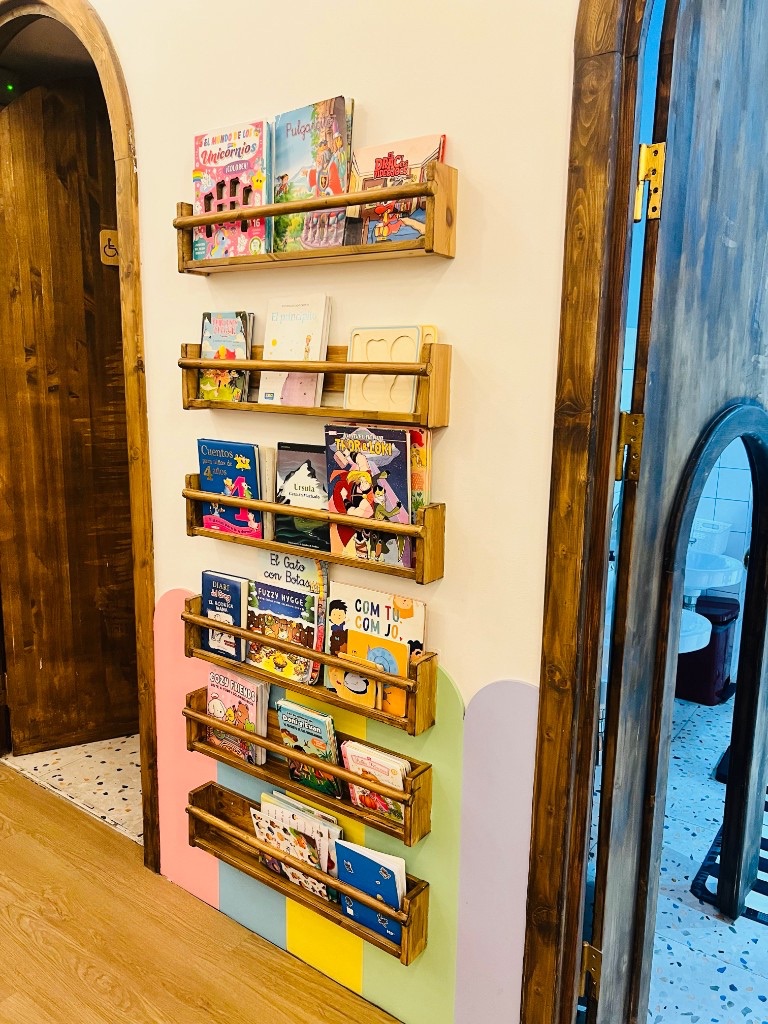 Puertas de madera y librería infantil en la zona de juegos de Charlie Restaurante